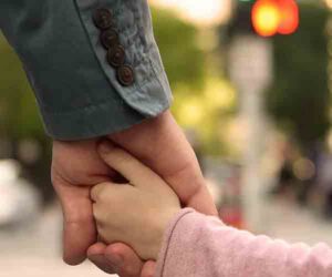 man holding daughter's hand close up