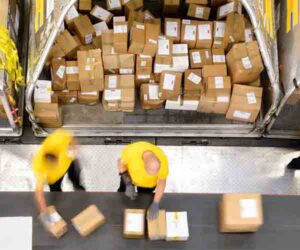 workers sorting packages on conveyor belt