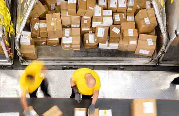workers sorting packages on conveyor belt